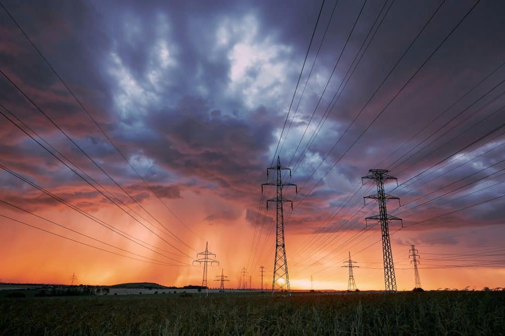 Power lines with storm at sunset