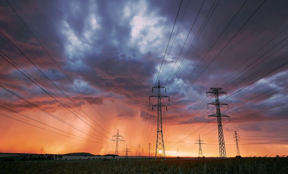 Power lines with storm at sunset