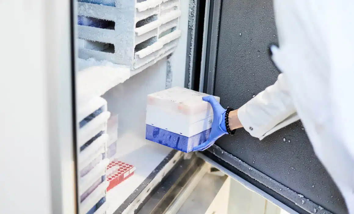 worker placing a container into a freezer